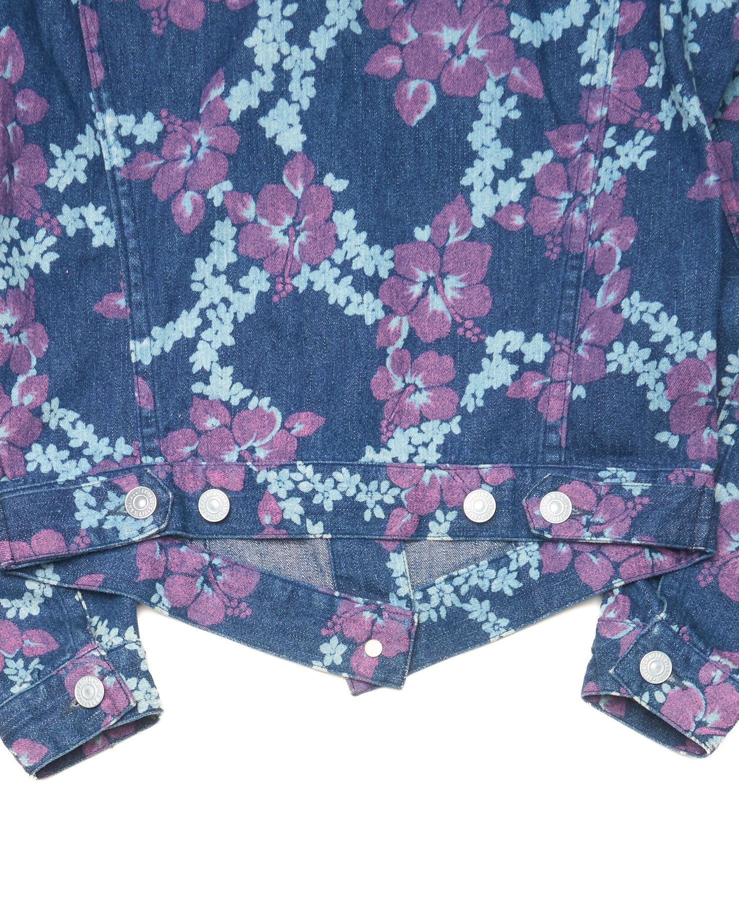 Close-up of a denim jacket with floral pattern on a white background