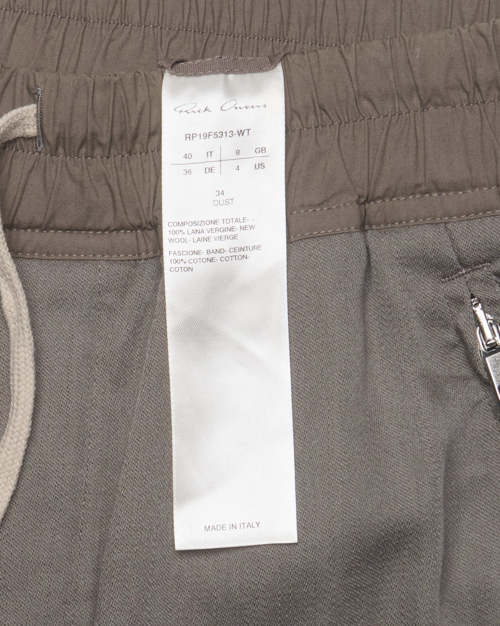 Close-up of gray pants with a label on the waistband