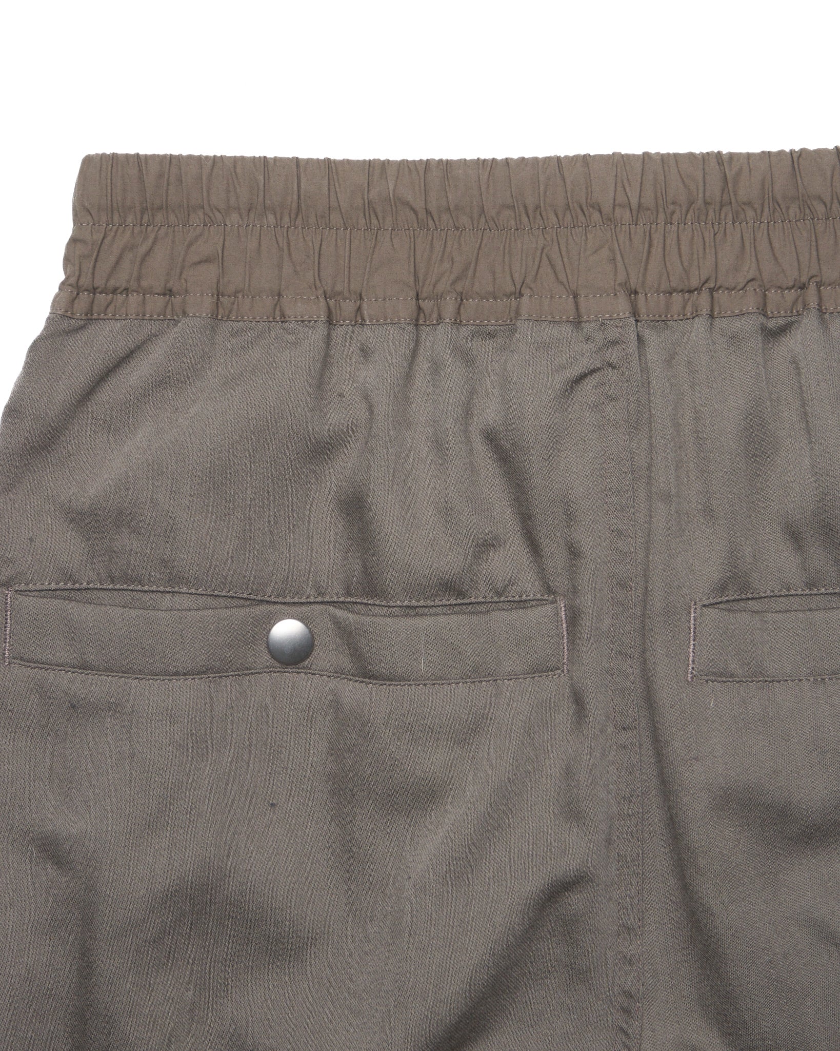 Close-up of gray shorts with a button on a white background