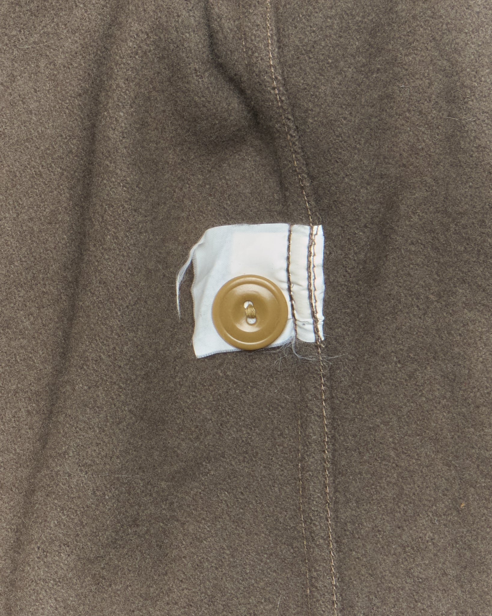 Close-up of a button on a brown fabric surface