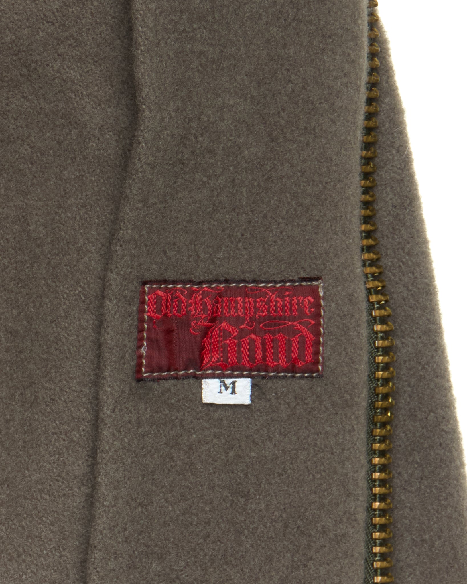 Close-up of a brown jacket with a red label on a white background