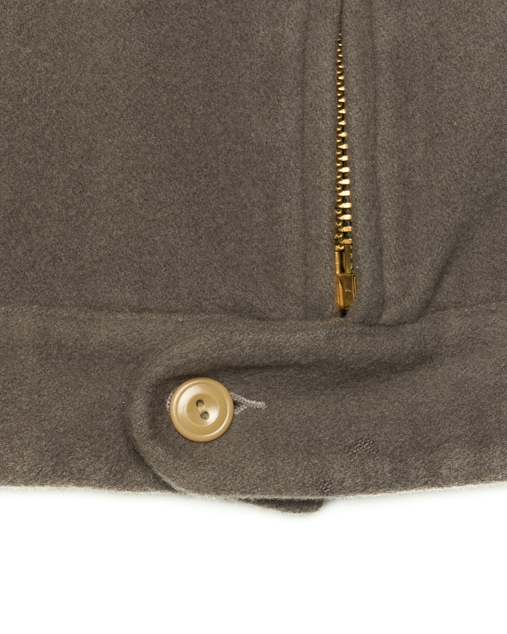Close-up of a brown coat with a gold button and zipper on a white background