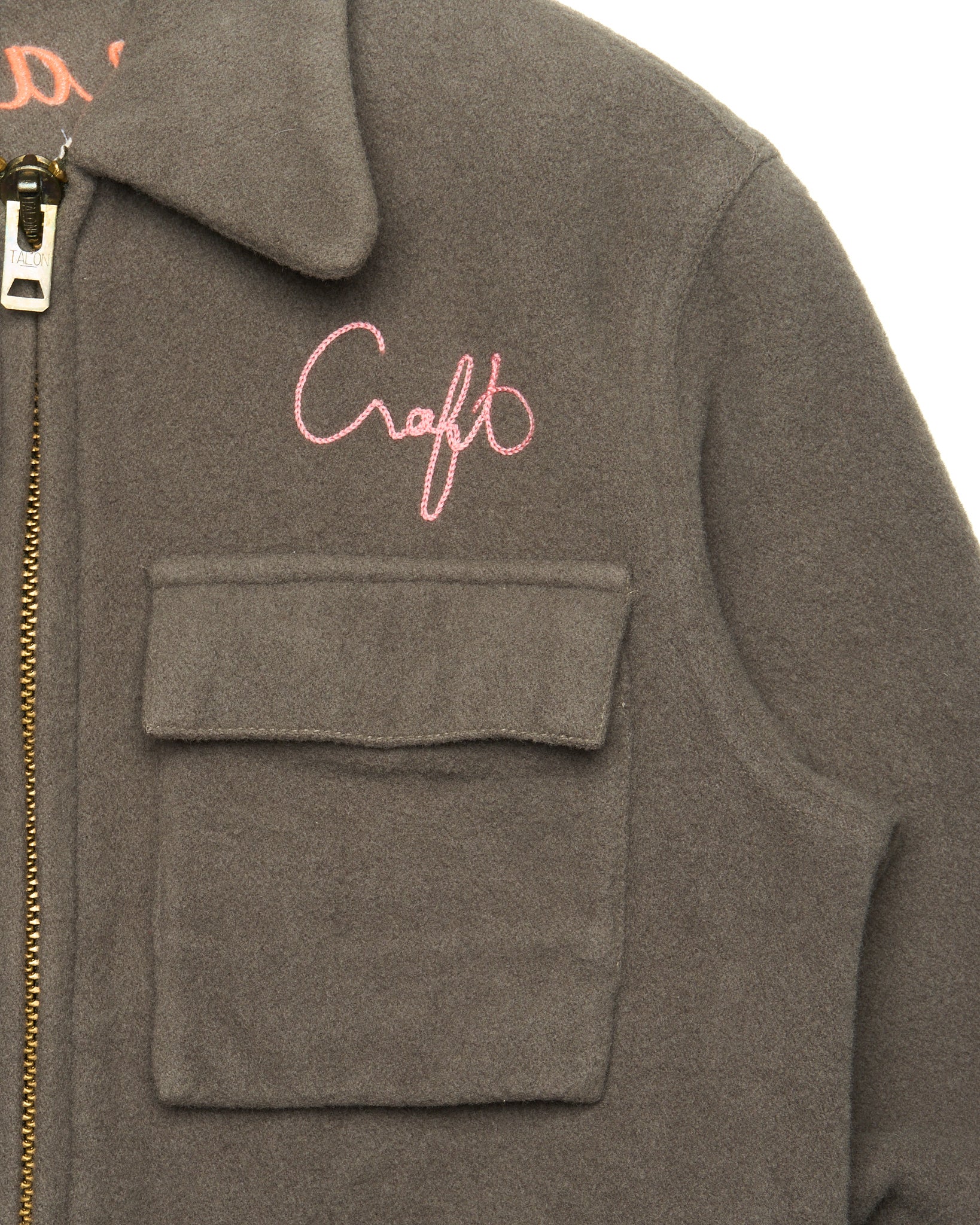 Gray jacket with pink 'Craft' logo on a white background