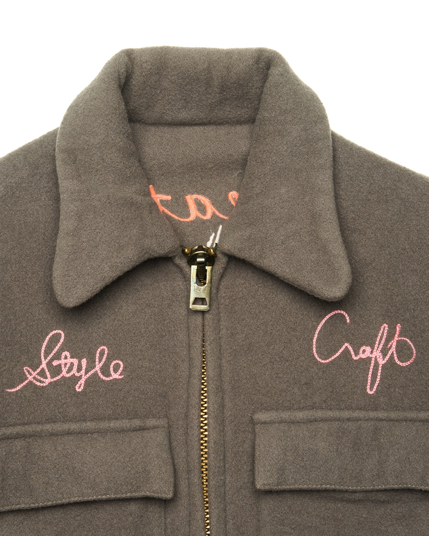 Gray jacket with pink embroidered text on a white background
