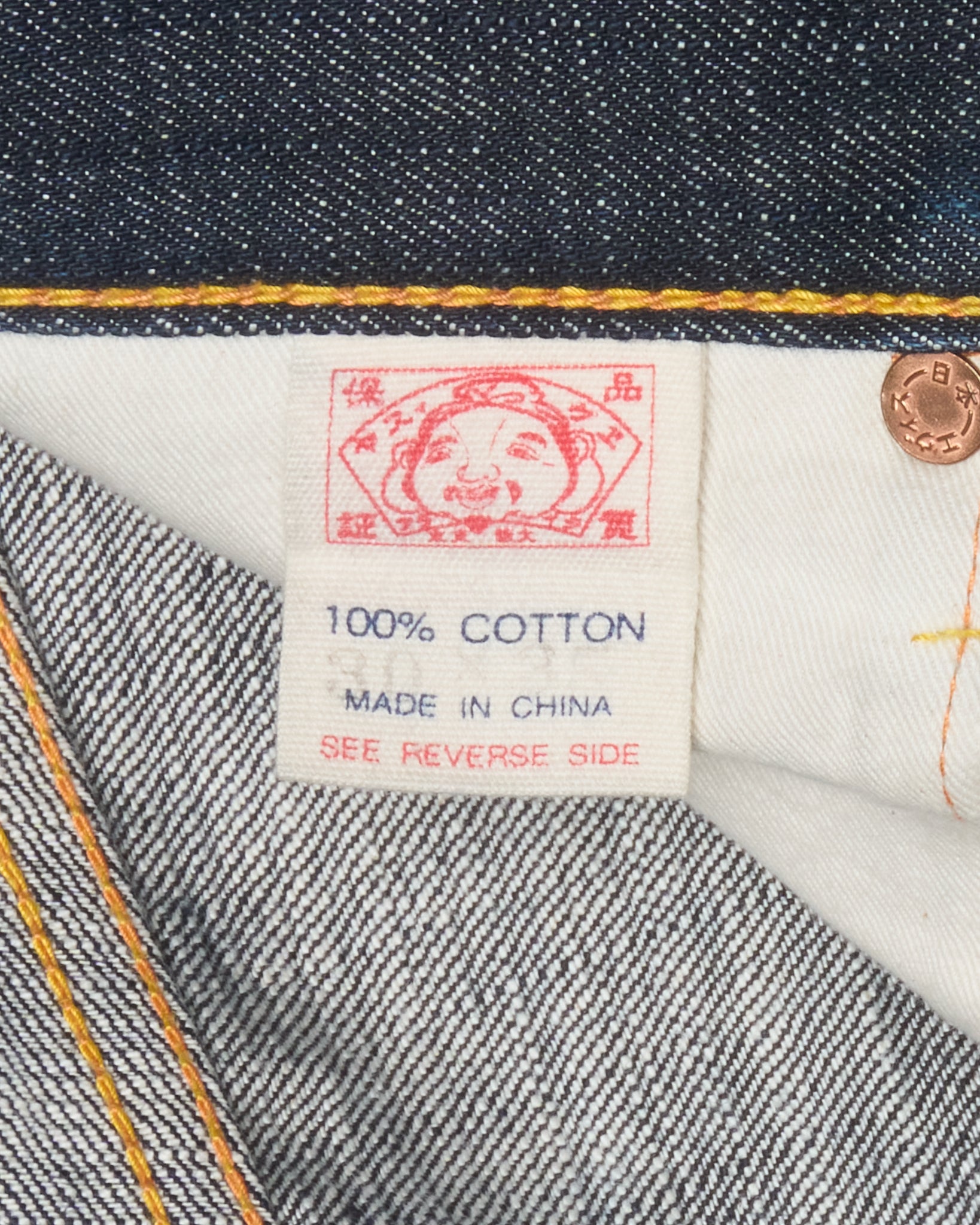 Close-up of a denim fabric with a label indicating 100% cotton and 'Made in China'.