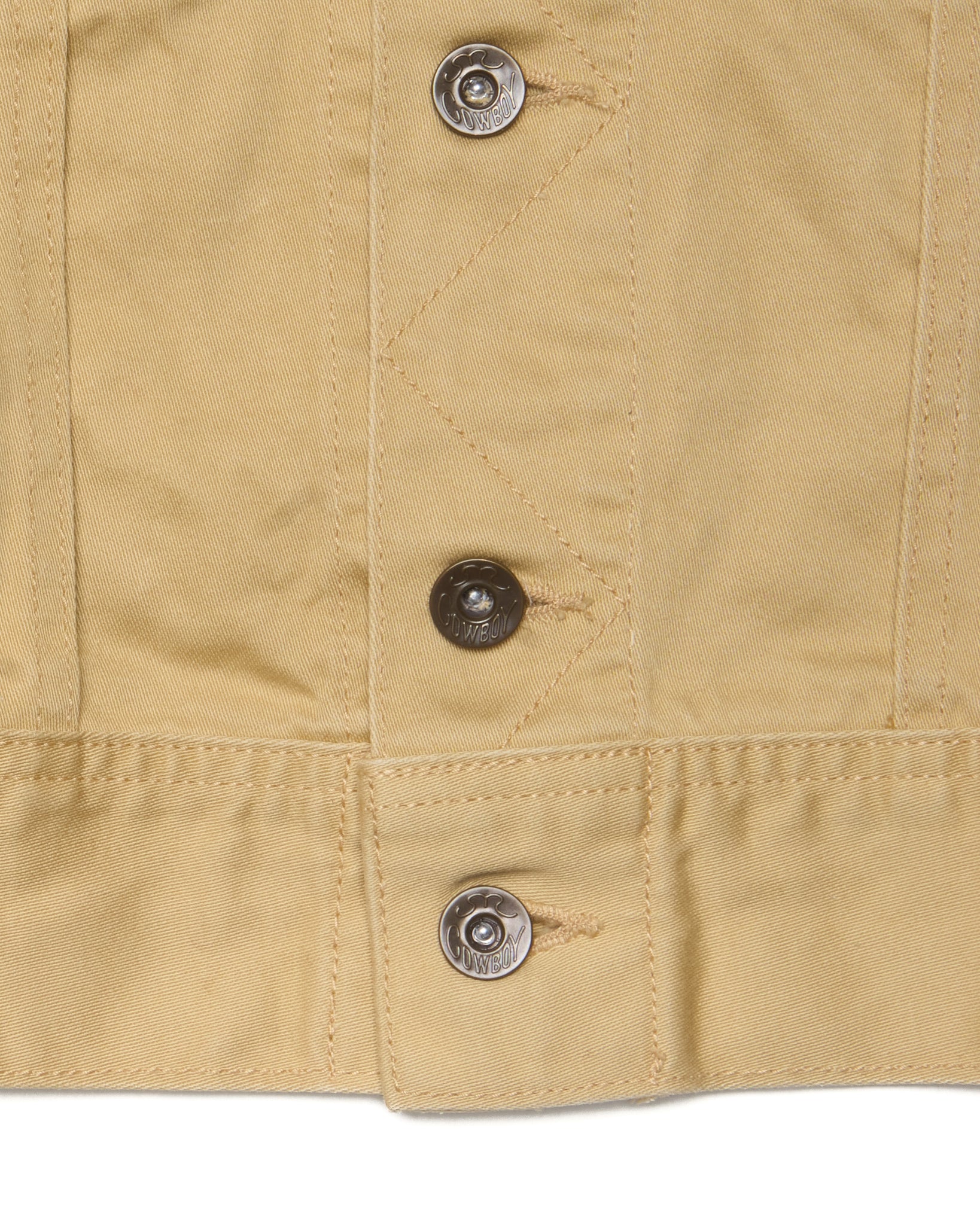 Close-up of beige fabric with metal buttons on a white background