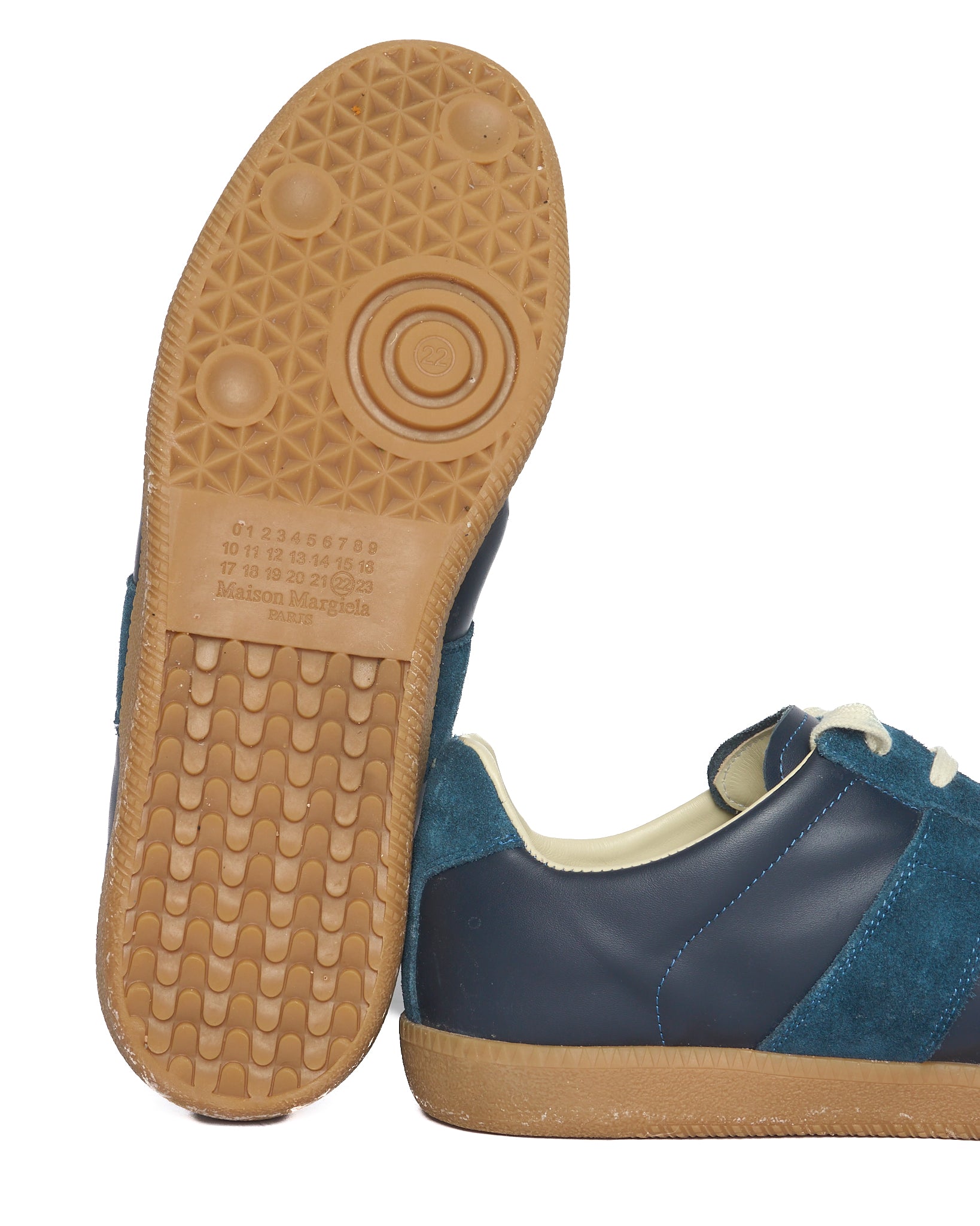 Navy blue sneaker with tan sole on a white background