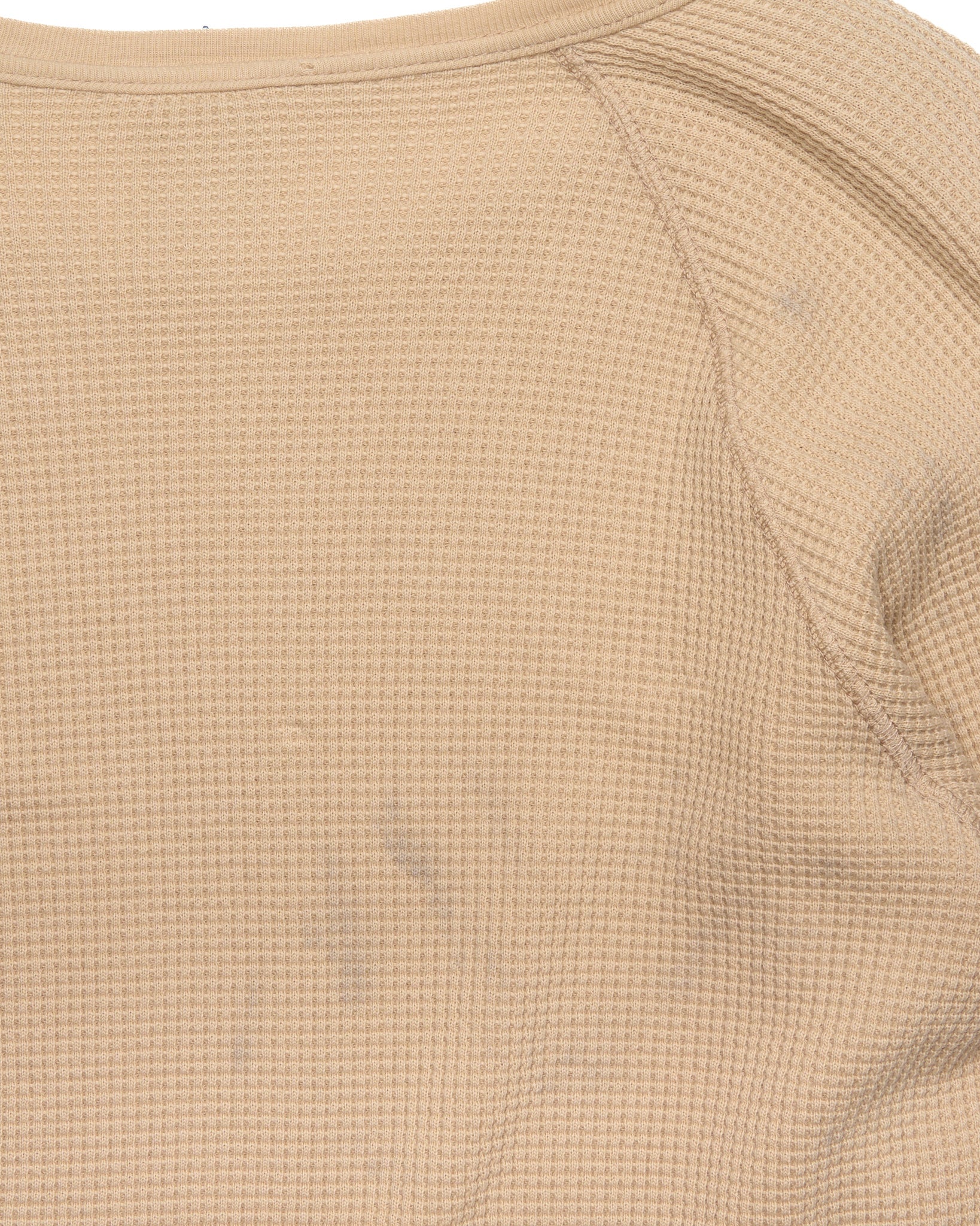 Close-up of a textured beige fabric with a subtle pattern