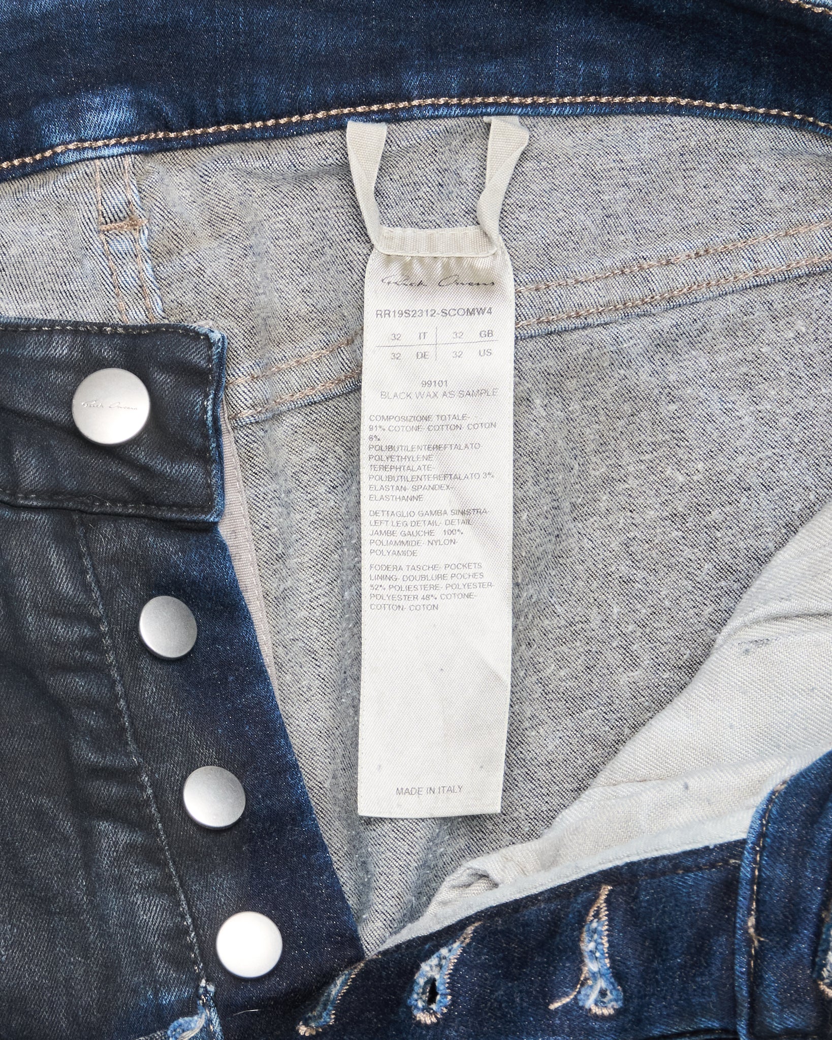 Close-up of a denim jacket with a brand tag attached