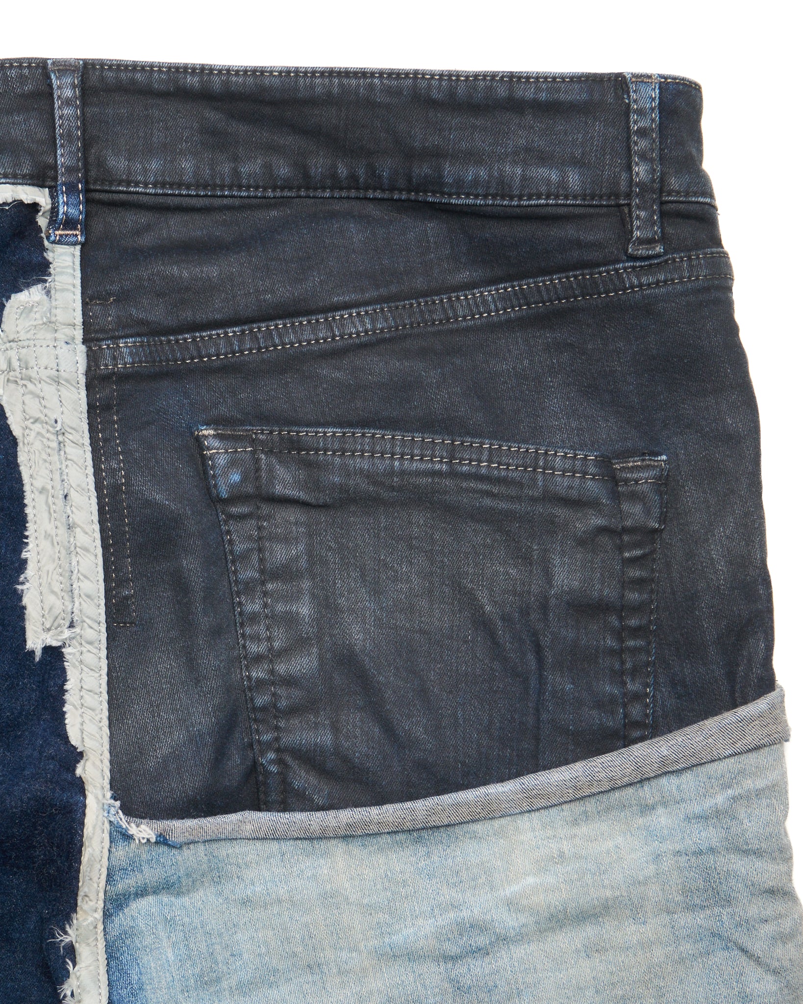 Close-up of a stack of blue jeans with frayed edges on a white background